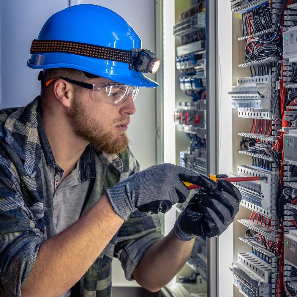 Elektriker schraubt an einem Sicherungskasten